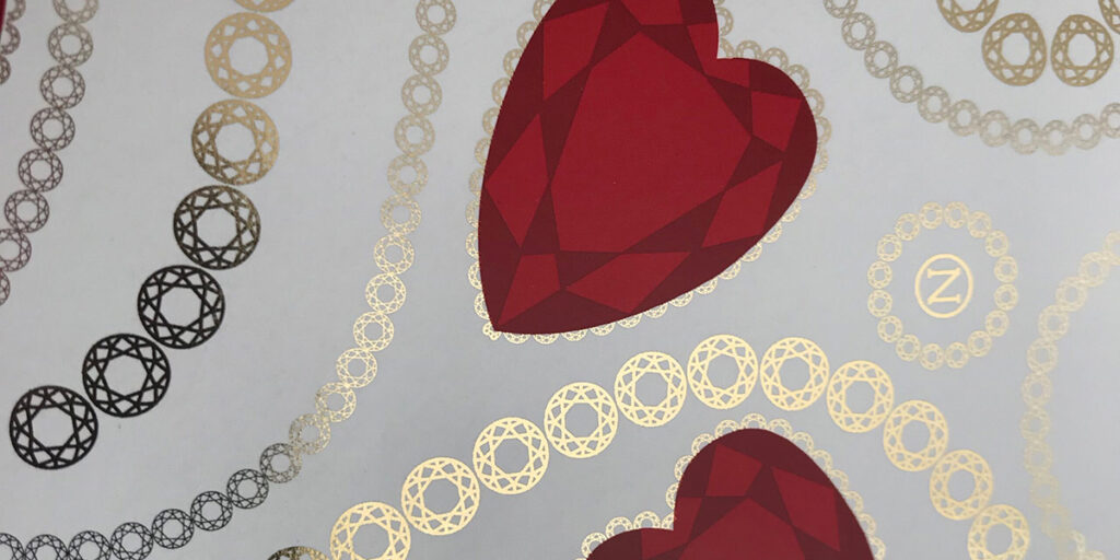 Rood hartvormig patroon gecombineerd met goudkleurige koudfolie op decoratief drukvel